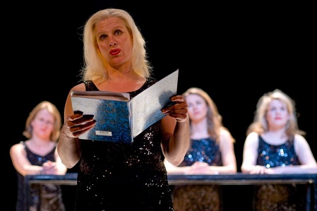 © Theater im Bahnhof Dier Damen in dunklen Glitzerkliedern, von denen eine aus einem Aktenordener rezitiert.