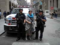 © Siegfried A. Fruhauf zwei bewaffnete polizisten vor einem auto, zwischen ihnen steht anna katharina laggner (an der wall street)