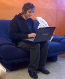 © Florian Horwath Mann auf einem Sofa sitzend mit Laptop am Schoß