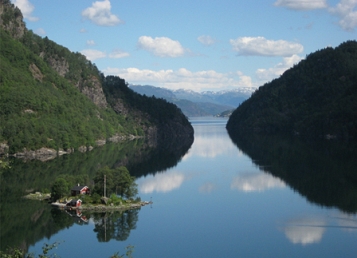 © ingrid gollackner norwegisches fjord mit kleiner insel mit kleinem roten haus und stall drauf