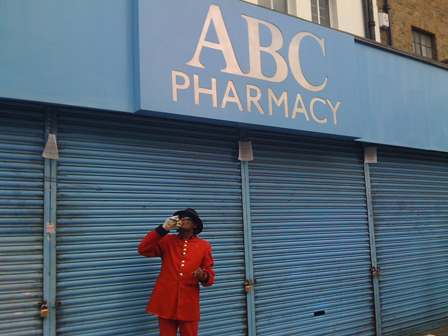 © fiva abc pharmacy geschaeft mit geschlossenen blauen rollos davor ein michael jackson lookalike in rotem anzug