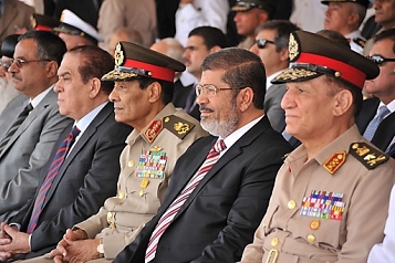 © EPA Ägyptens Präsident Morsi sitzt zwischen 2 ranghohen Offiziere des Militärs bei einer Zeremonie Anfang Juli