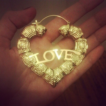 © http://denafromtheblock.com/ Hand mit einem goldenen Herzen und der Inschrift "Love"