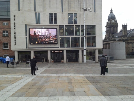 © public domain Leerer Platz, drei Zuseher bei Thatcher-Begräbnis-Übertragung in Leeds