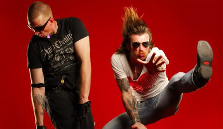 Die beiden Mitglieder der Band Eagles of Death Metal vor rotem Hintergrund