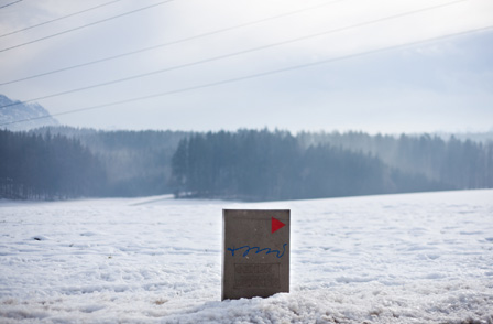 Eine Wegmarkierung in einer verschneiten Landschaft