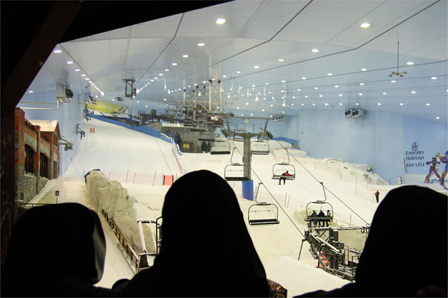 © Flo Rainer Zwei Dubaierinnen schauen durch eine Glasscheibe auf die Skihalle