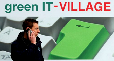 Mann mit Handy vor einem green IT Village Plakat auf der CeBit 08