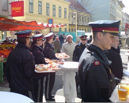 junge Polizeibeamte mit Tabletts voller Brötchen am Brunnenmarkt