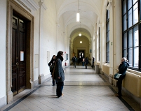 Ein Gang in der Universität Wien, vereinhzelt von Studenten bevölkert.