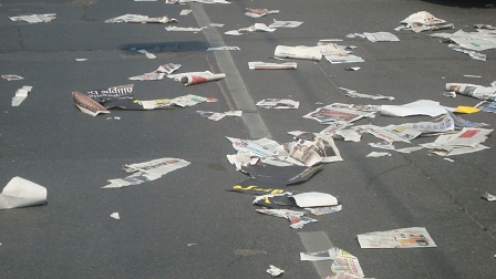 Eine Straße, bedeckt mit zerfledderten Tageszeitungen.