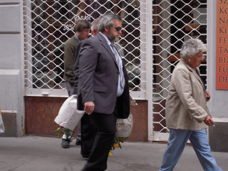 Menschen mit Blumensträußen auf dem Gehweg.