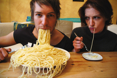 Mann mit sollen Nudelteller, frau mit einem Spaghetti