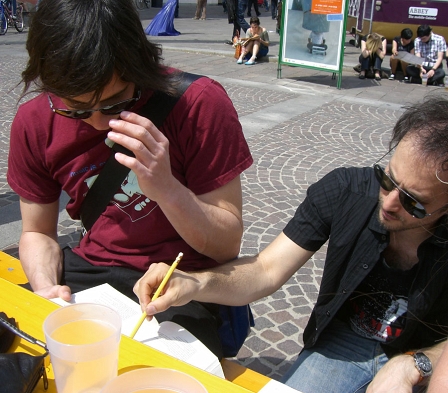 Junger Mann und Michael Ostrowski suchen Witze aus Buch aus