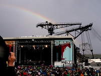 Regenbogen und schwere Stahlgeräte hinter einer OpenAir Bühne