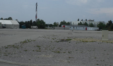 Ein Schotterparkplatz: im Hintergrund ein altes Campingmobil.