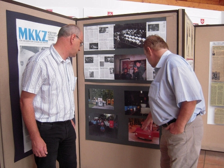 2 männer schauen sich fotos in einer ausstellung an 