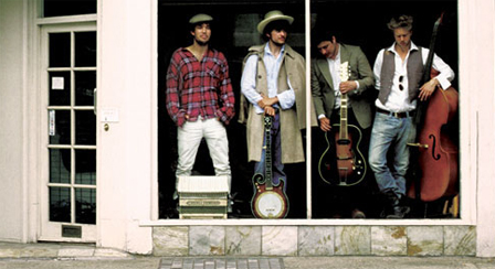 Mumford & Sons, mit ihren Instrumenten in einem Schaufenster