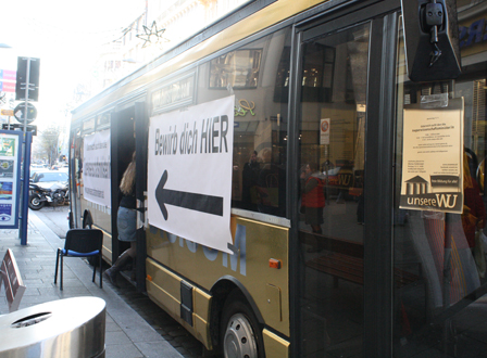 Goldener Bus mit offener Tür und Aufschrift "Bewirb dich"