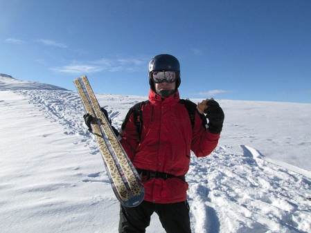 Skifahrer hält seine sexy Leopardenmuster Steigfelle in die Kamera