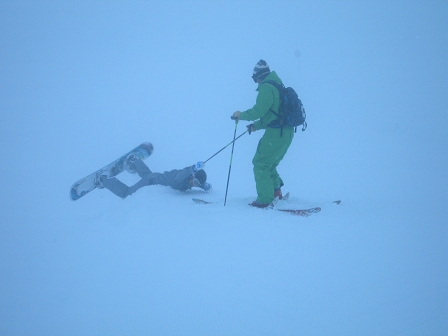 snowboarder und skifahrer im schnee