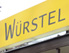 Schild mit der Aufschrift Würstel vom Vinzi-Würstelstand