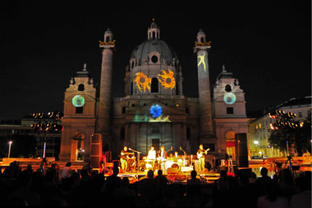 Nacht: Bühne vor großer Kirche, auf die Lichtprojektionen geworfen werden