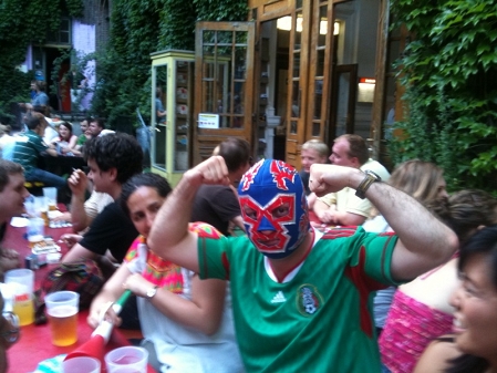 Mann in mexakinischem Fußballtrikot und mit mexikanischer Lucha Libre Maske.