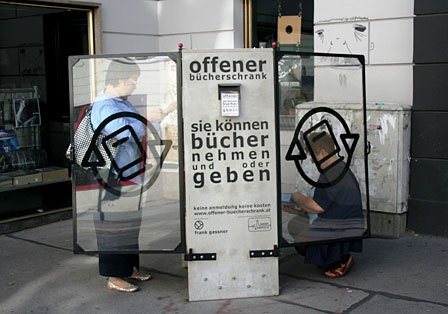 Zwei Personen schmökern im "offenen Bücherschrank"