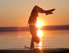 paddler im handstand vor sonnenuntergang