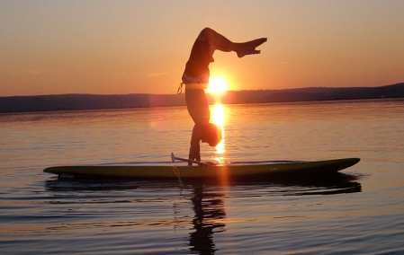 mann auf longboard macht handstand