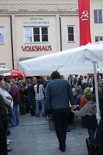 Rote Fahne mit Hammer und Sichel hängt neben dem Volkshaus