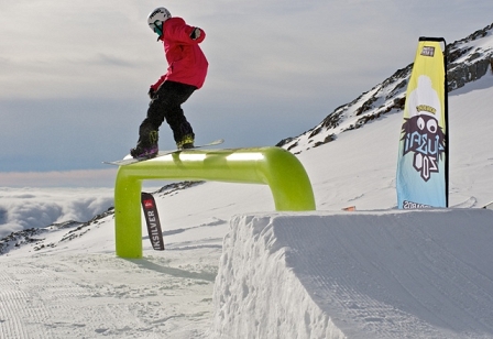 © 5 Stars Snowboarder beim Boardslide über ein grünes Rail