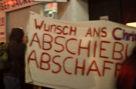 Demonstranten halten ein Transparent "Wunsch ans Christkind: Abscxhiebung abschaffen"