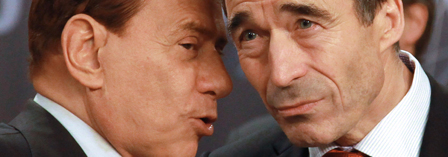 Italian Prime Minister Silvio Berlusconi whispers to NATO Secretary General Anders Fogh Rasmussen 