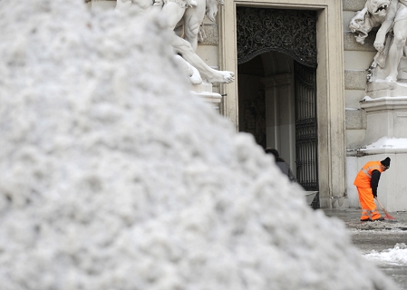 Schneehaufen mit Schneearbeiter im Hintergrund