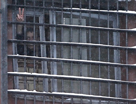 A man shows the 'Victory' sign from a barred window of a prison in Minsk, Belarus