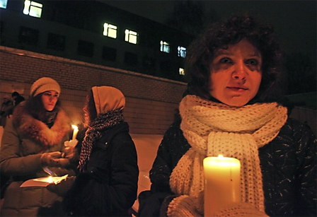 Relatives and friends of arrested Belarussian opposition supporters hold candles outside the prison walls as a sign of solidarity with the detained