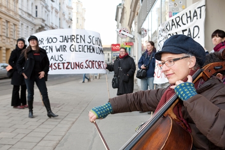 Demo 20000 Frauen. Banner für gleiche Löhne. Im Vordergrund: Chellistin