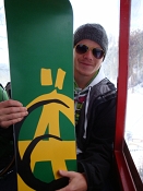 Stephan Kondert mit Sonnenbrille und seinem nagelneuen Snowboard in der roten Gondel der Zauchenseer Bergbahnen
