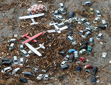 Airplanes and cars are covered with debris at Sendai airport 