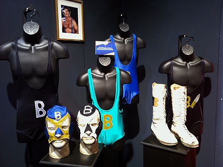 © Maciej Palucki Zwei Lucha-Libre-Masken sowie ein paar weiße Wrestling-Stiefel und bunte Oberteile.