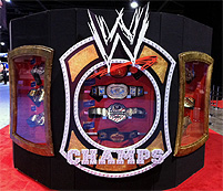 © Maciej Palucki Eine große, mehreckige Vitrine mit mehreren Schaufenstern. Drinnen sieht man Wrestling-Merchandise-Produkte, draußen die große, weiße Aufschrift "WWE Champs".