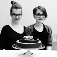 © eva eisner (Eva links, Nina rechts) schwarz weiss portrait der schwestern hinter einer grossen torte