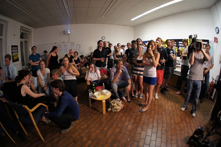 Menschen in der ÖH Wahlzentrale schauen gespannt auf die Leinwand mit den Ergebnissen.