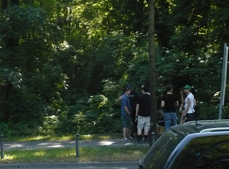 Männer, die in einem Park um eine Holzkiste im Kreis stehen