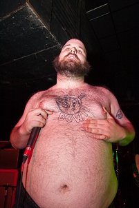 © fusedmagszine.com Fucked Up Sänger Pink Eyes, fotografiert mit Fischauge, sein riesiger Bauch im Vordergrund