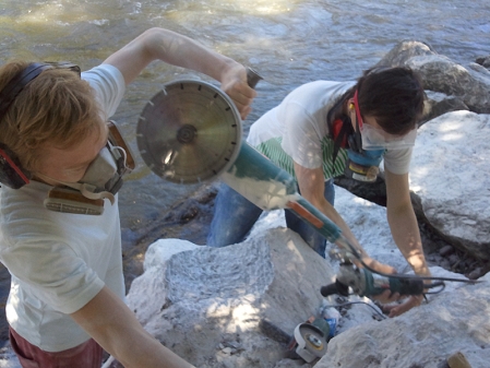 Zwei junge Männer flexen Steine am Murufer in Graz.