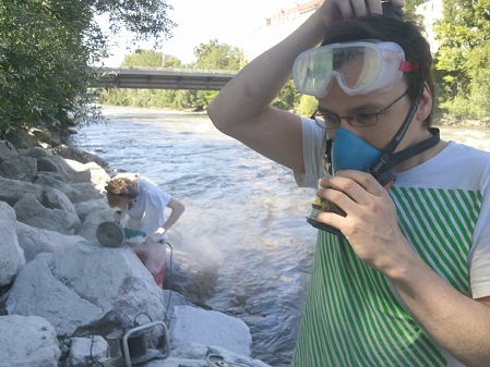 Tobias Kestel setzt sich eine Atemschutzmaske und eine Schutzbrille zum Arbeiten auf. 