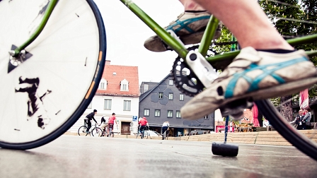 Abgestützt auf den Schläger steht ein Spieler auf seinem Fahrrad sitzend still vor dem Tor